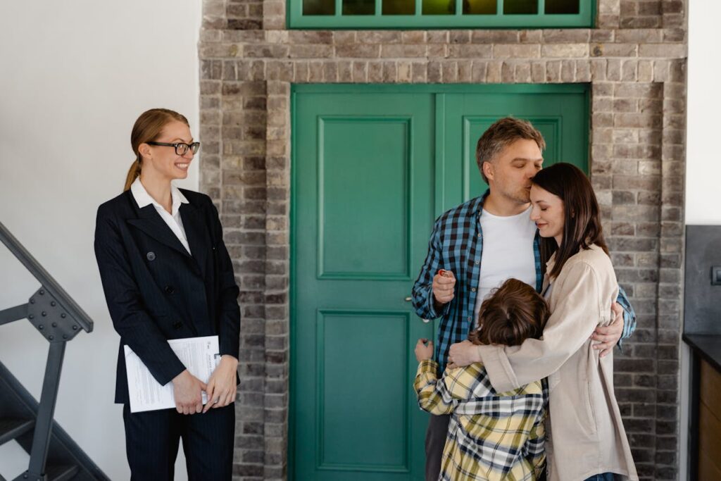 family hug next to real estate after putting property for sale