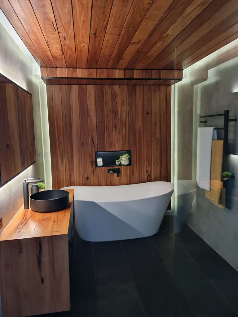 bathroom featuring a white bathtub and wooden walls and ceiling