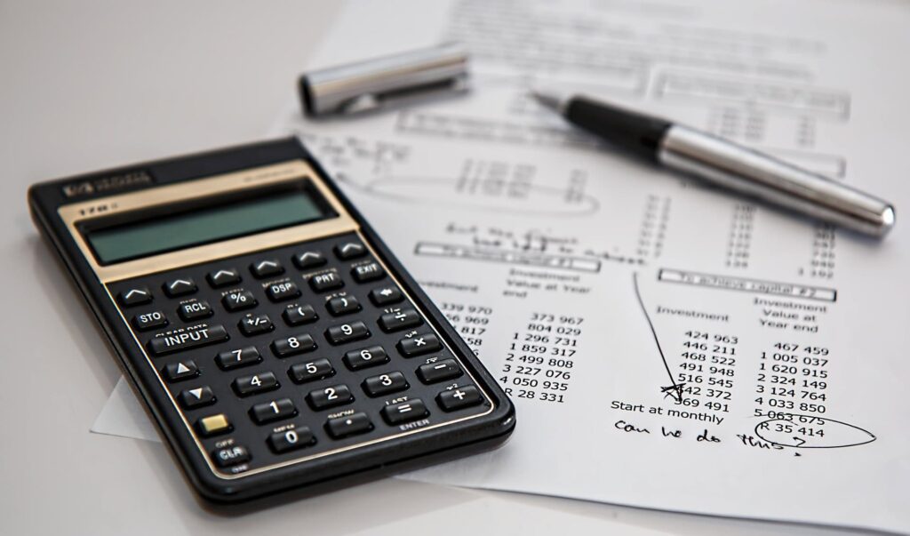 calculator with a piece of paper and some numbers wrote in it